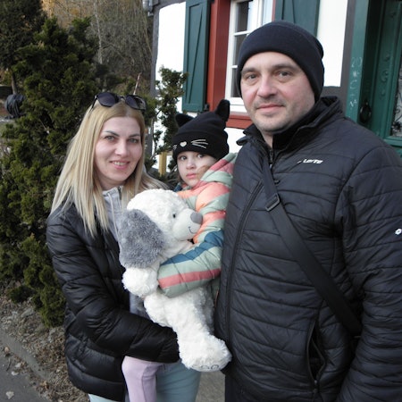 Anna Dehtiarinska, ihr Mann Denys Dehtiarinsky und ihre Tochter stehen vor einem Eifeler Fachwerkhaus.