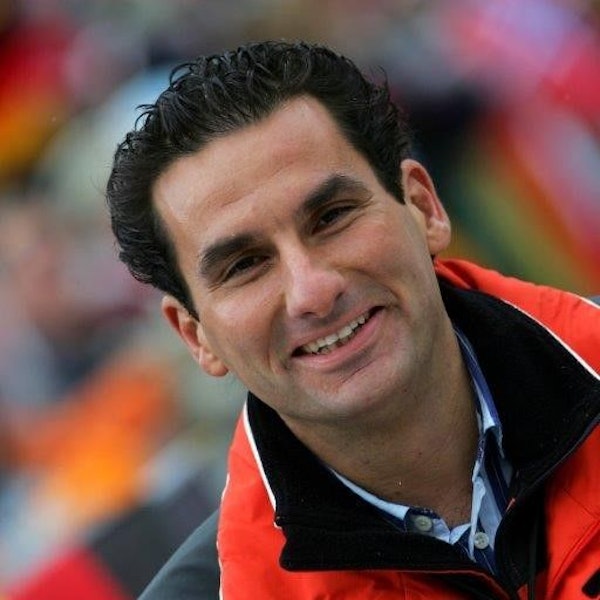 Auf dem Bild ist ein lächelnder Mann mit dunklem Haar zu sehen.