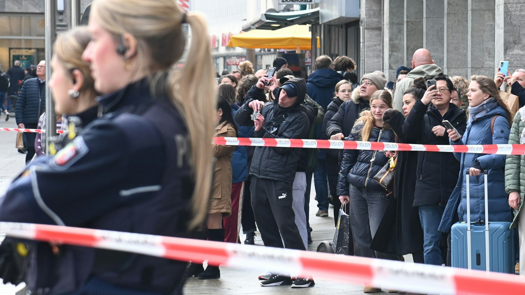 Reisende und Schaulustige vor der Absperrung auf der Domplatte.