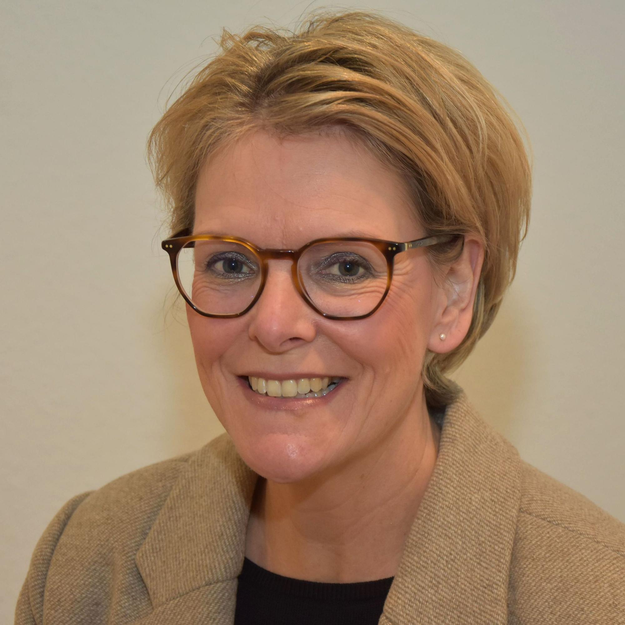 Eine blonde Frau lächelt.