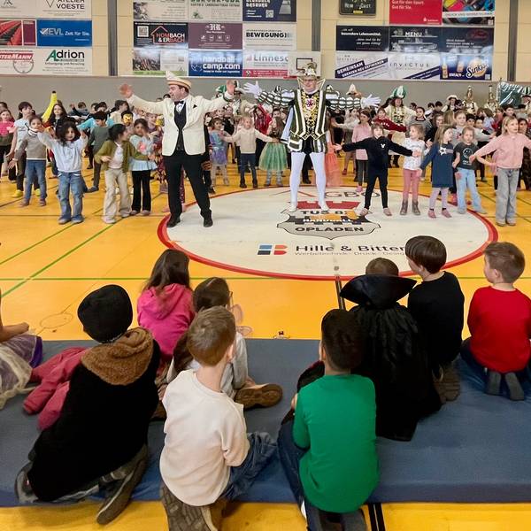Prinz und Kinder tanzen in einer Turnhalle
