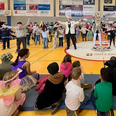 Prinz und Kinder tanzen in einer Turnhalle