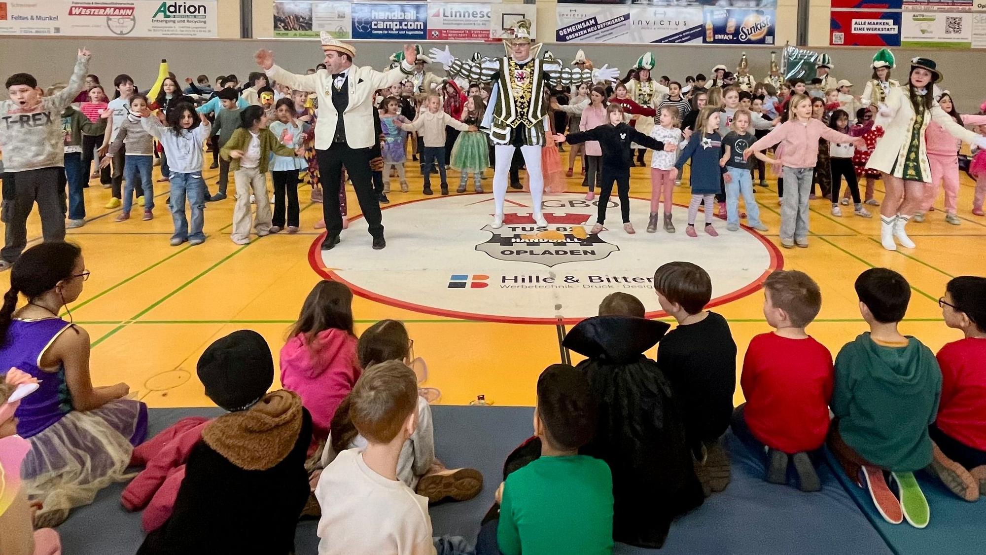 Prinz und Kinder tanzen in einer Turnhalle