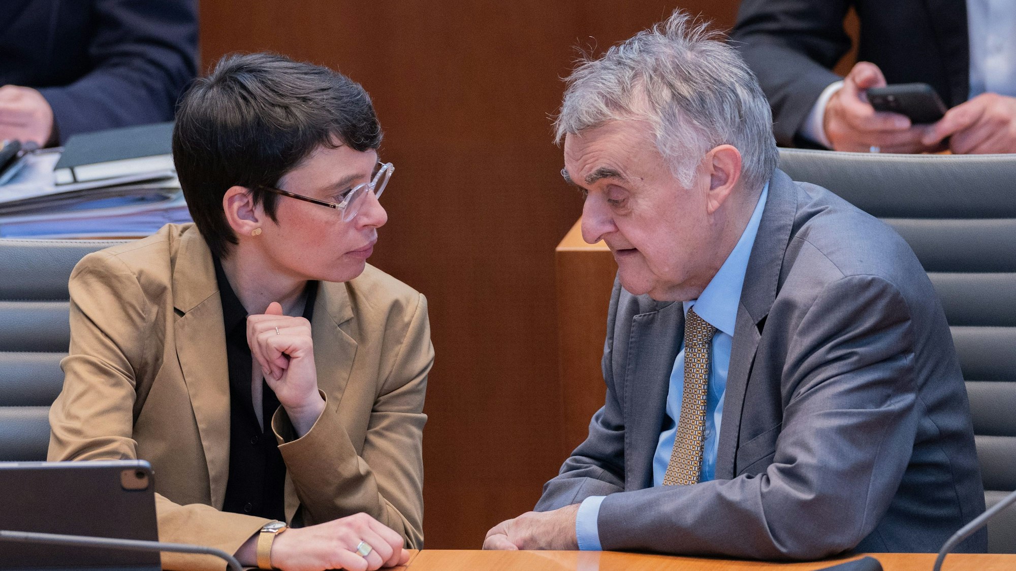 Herbert Reul (CDU), Innenminister von Nordrhein-Westfalen, und Josefine Paul (Bündnis 90/Die Grünen), Ministerin für Kinder, Jugend, Familie, Flucht und Integration in Nordrhein-Westfalen, unterhalten sich im Plenum des Landtags.
