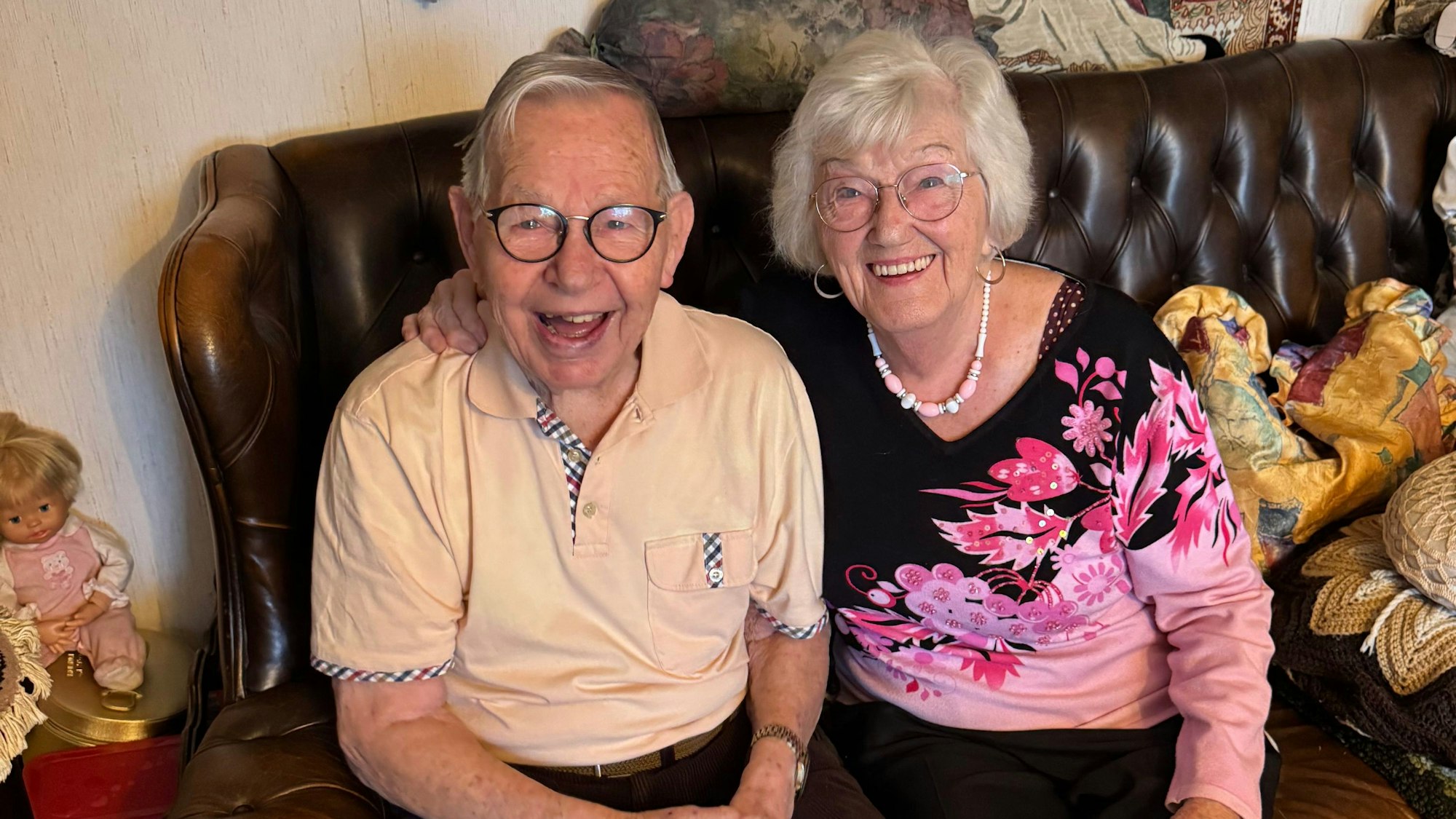 Ein Ehepaar sitzt auf einer Couch.