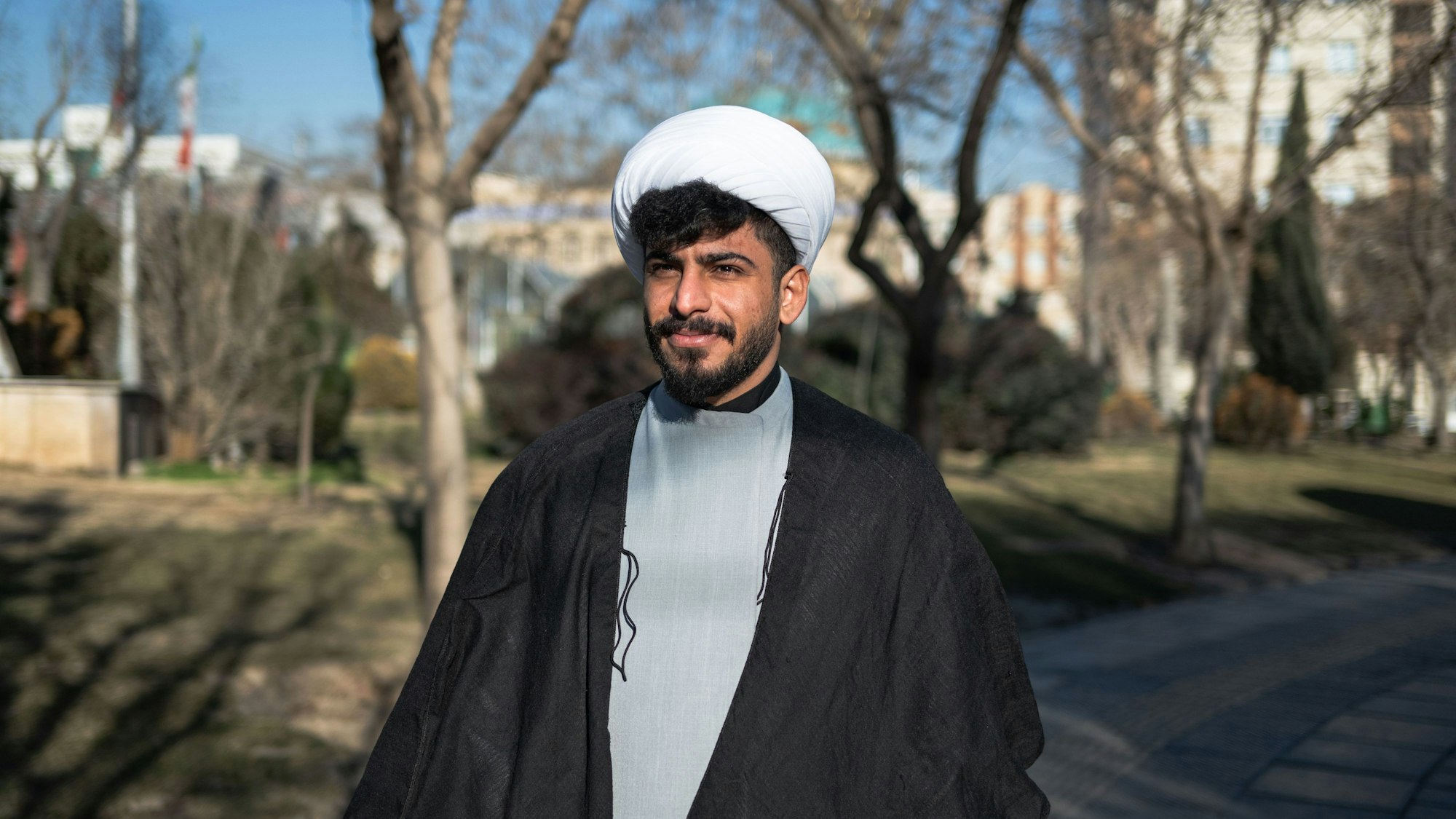 Erfan Chasai, Geistlicher und Bodybuilder, steht in einem Park.