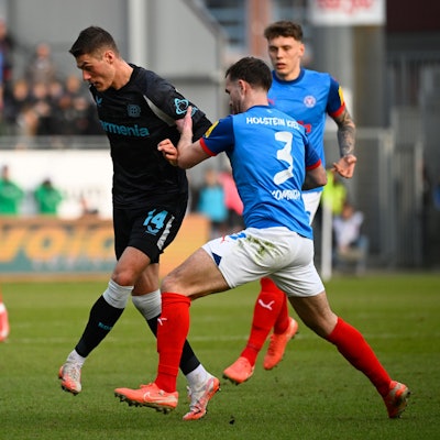 22.02.2025, Schleswig-Holstein, Kiel: Fußball: Bundesliga, Holstein Kiel - Bayer Leverkusen, 23. Spieltag, Holstein-Stadion. Leverkusens Patrik Schick (l-r) setzt sich gegen Kiels Marco Komenda durch. Foto: Gregor Fischer/dpa - WICHTIGER HINWEIS: Gemäß den Vorgaben der DFL Deutsche Fußball Liga bzw. des DFB Deutscher Fußball-Bund ist es untersagt, in dem Stadion und/oder vom Spiel angefertigte Fotoaufnahmen in Form von Sequenzbildern und/oder videoähnlichen Fotostrecken zu verwerten bzw. verwerten zu lassen. +++ dpa-Bildfunk +++
