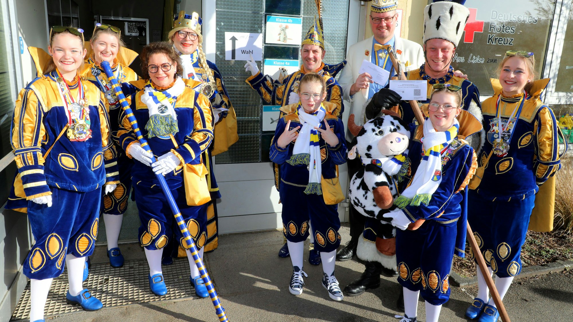 Das Overather Dreigestirn steht mit seinem Gefolge vor einem Wahllokal in Overath-Vilkerath.