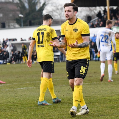 Frederic Baum reckt die Arme und geht über den Platz.