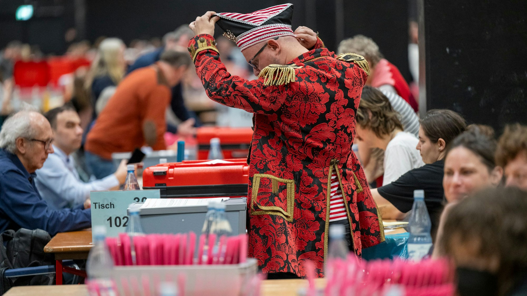 Menschen befinden sich bei der Briefwahl zur Bundestagswahl 2025 in der Kölnmesse.
