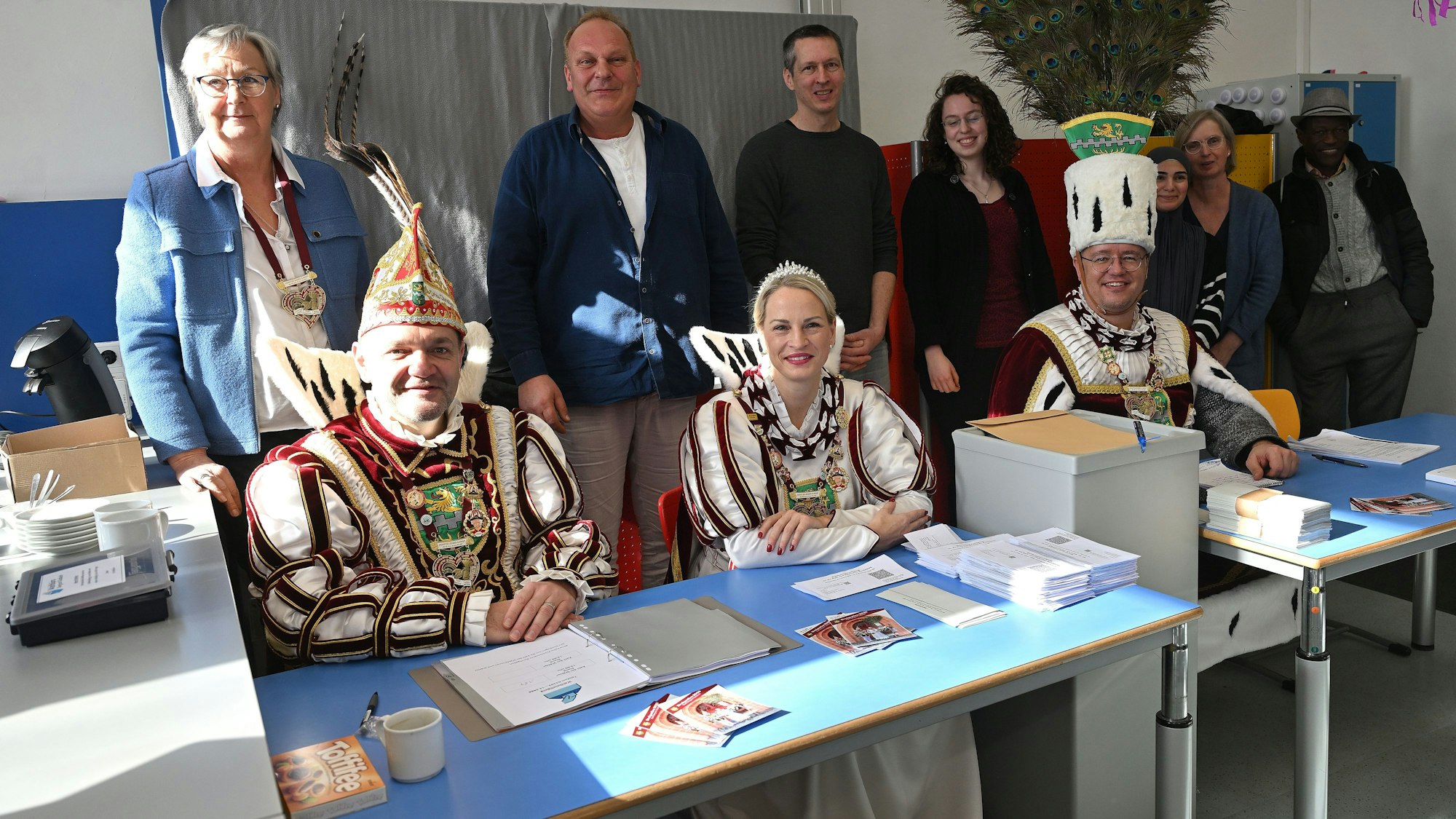 Bergisch Gladbachs Dreigestirn sitzt am Sonntagnachmittag (23.2.) am Tisch des Wahlvorstand (stehend dahinter) in der Grundschule im Bergisch Gladbacher Stadtteil Gronau.