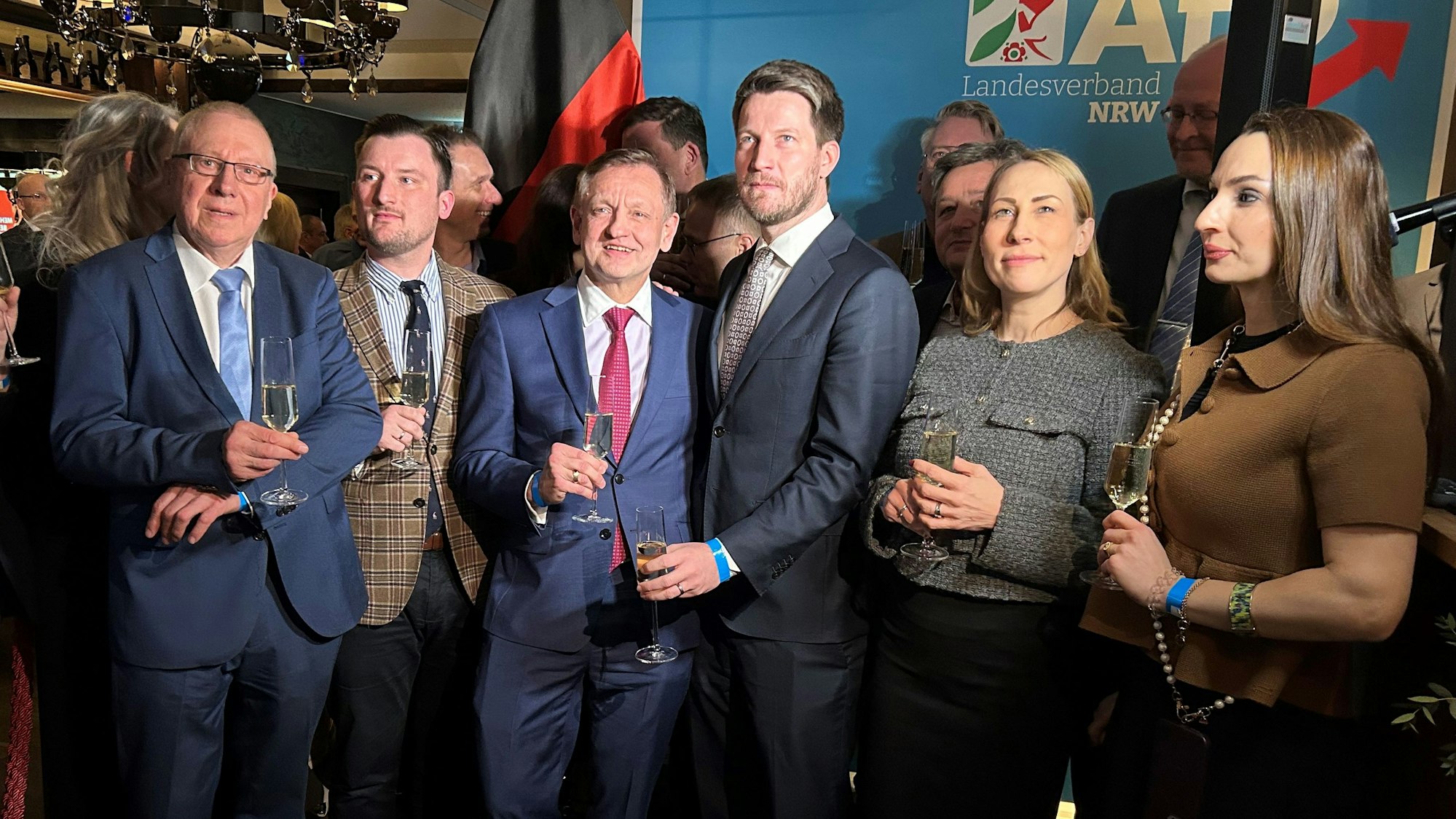 Eine Gruppe von Männern und zwei Frauen sind auf einem Gruppenbild bei der Wahlparty zu sehen.