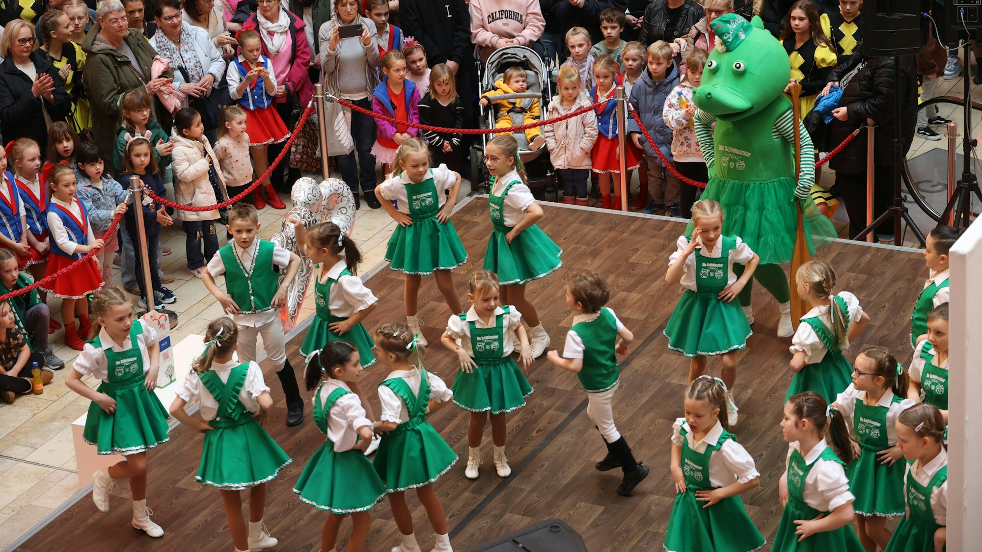 Kinder tanzen vor Publikum einen Karnevalstanz.
