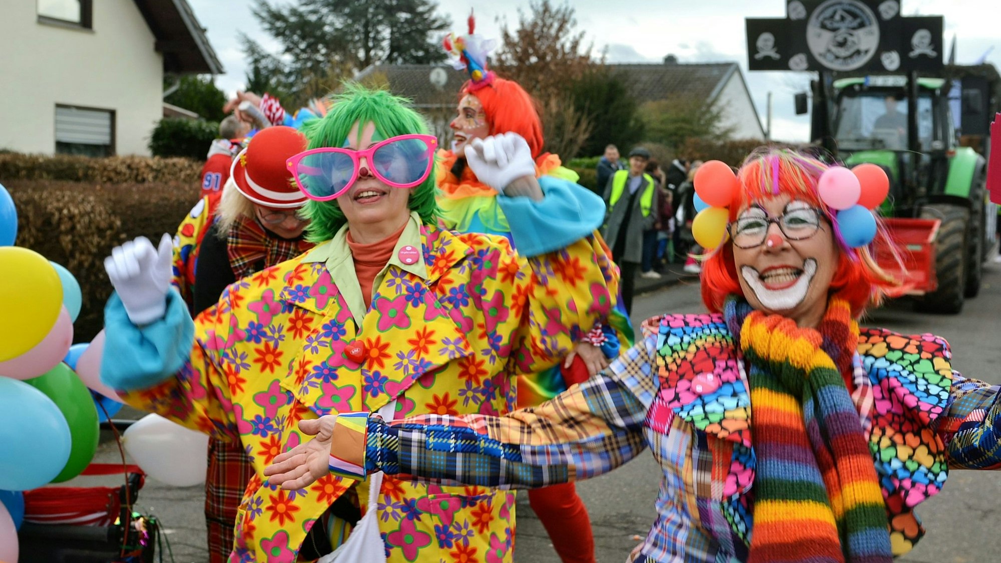 Mehrere Jecken in bunten Clownkostümen sind zu sehen.