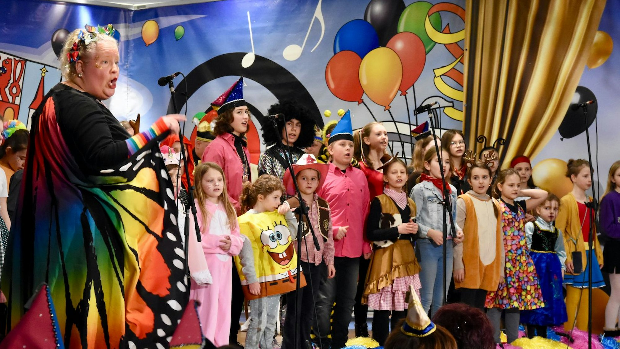 Kostümierte Kinder und Jugendliche auf einer Bühne.