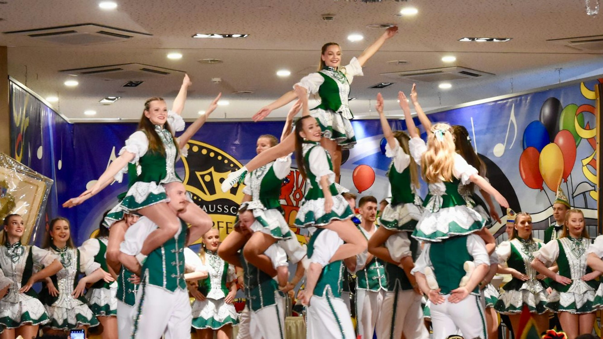 Eine karnevalistische Tanzformation in grün-weißen Kostümen.