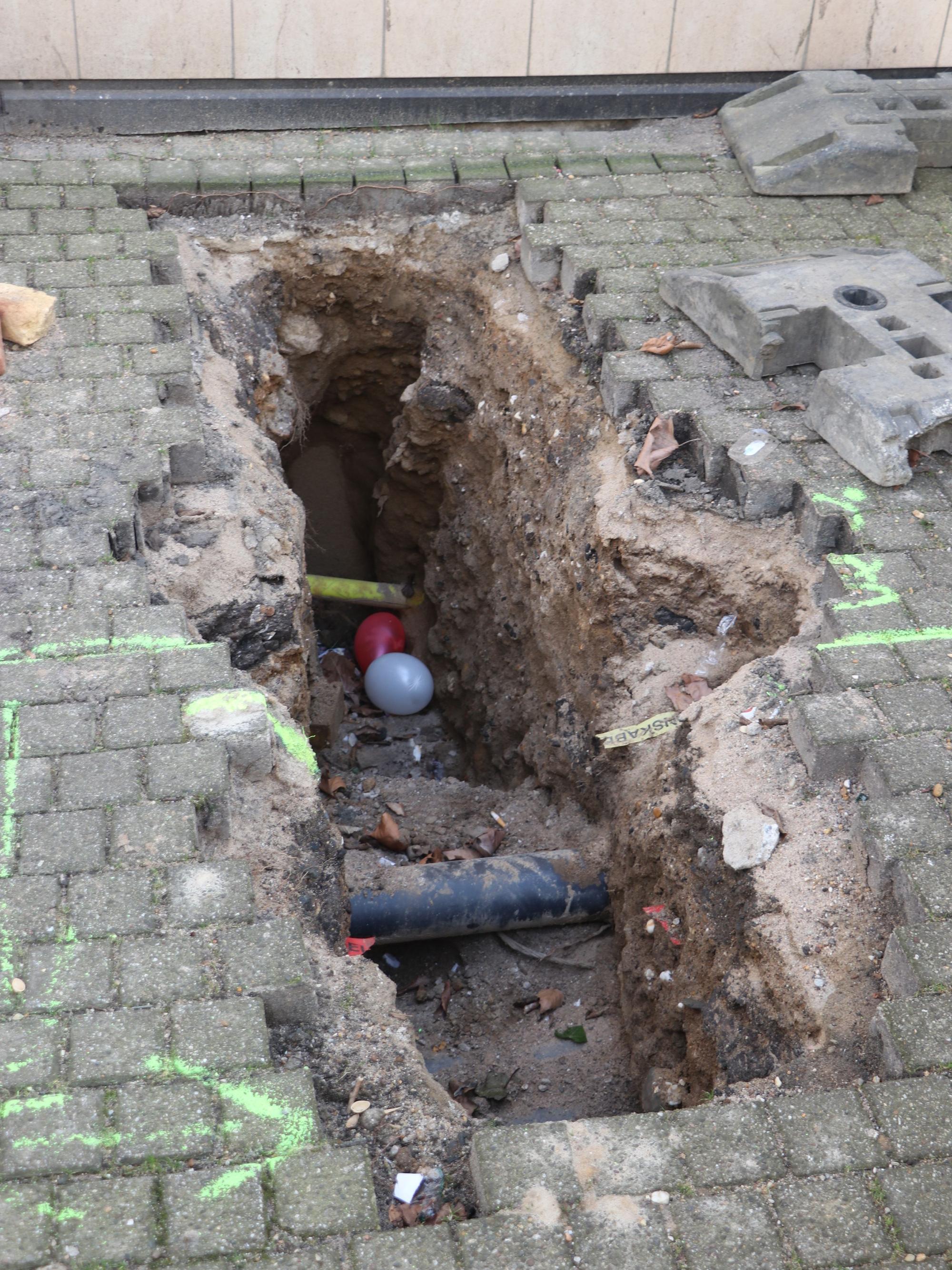 Auf dem Bild ist ein aufgerissener Pflasterboden zu sehen, der von Archäologen untersucht wurde.