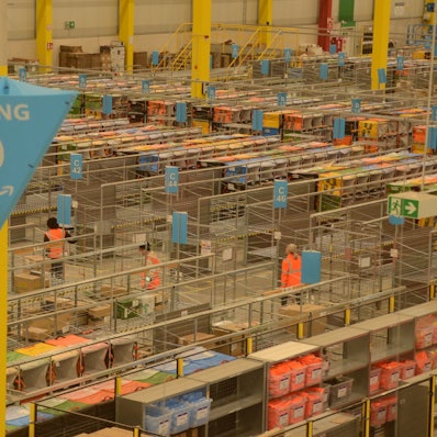 Amazon-Verteilzentrum in Troisdorf, "letzte Meile" im Netzwerk von Amazon, an 9 Toren kommen zwischen 2 und 9 Uhr die Lkw an, zehn bis 15 fahrzeuge pro Schicht. Dafür arbeiten am Zündorfer Weg je Schicht etwa 70 Beschäftigte.