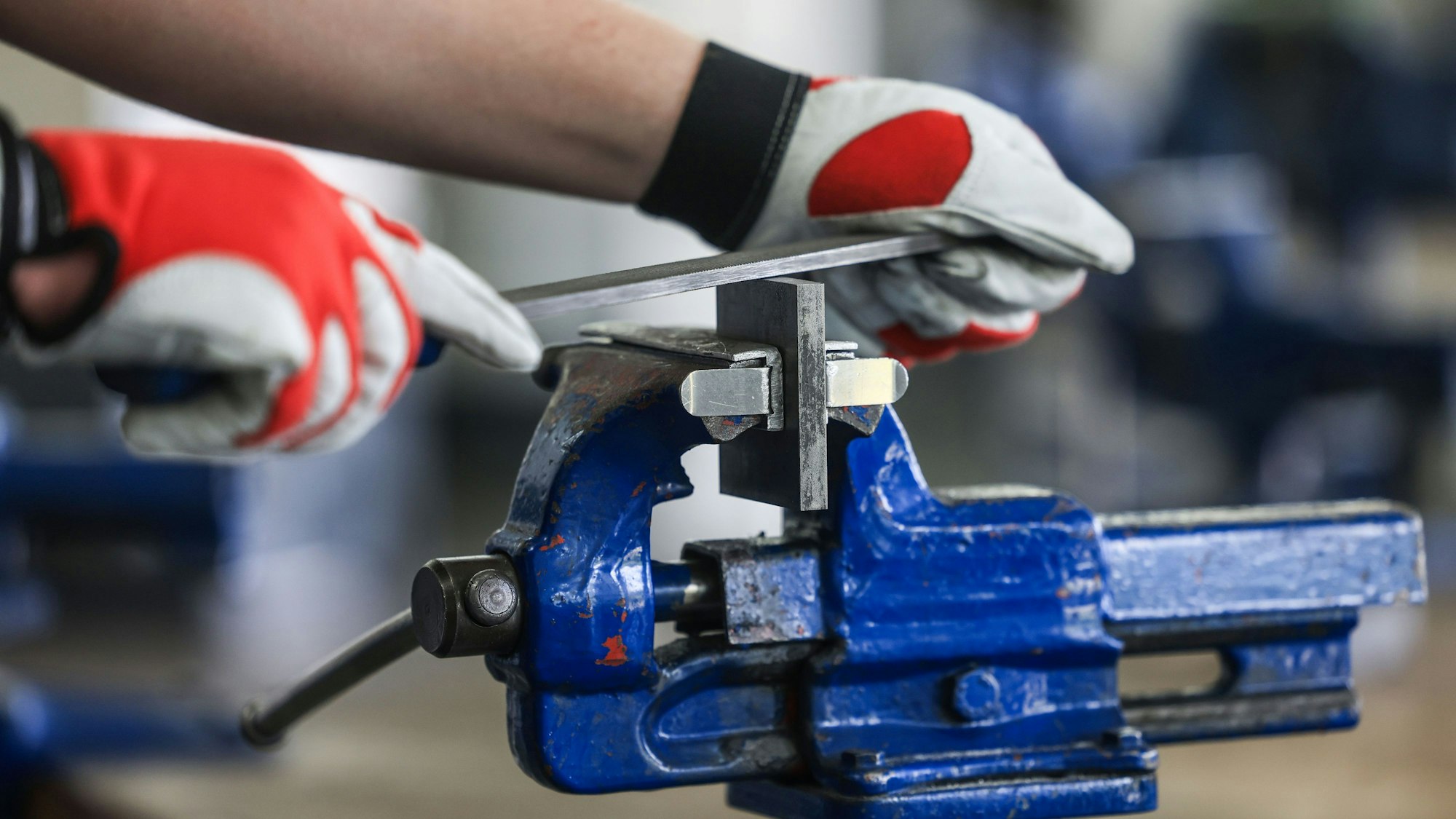 ARCHIV - 18.06.2024, Rheinland-Pfalz, Dörth: Ein Auszubildender zum Mechatroniker bearbeitet in einer Ausbildungswerkstatt an einem Schraubstock ein Werkstück. (zu dpa: «Maschinenbauer halten Belegschaft stabil - noch») Foto: Oliver Berg/dpa +++ dpa-Bildfunk +++