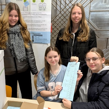 Die Wahlhelferinnen der Juniorwahl an der Euskirchener Marienschule mit Wahlurne und Stimmzettel.