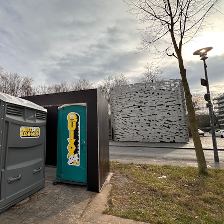 Mobile Toilette vor einer Umhausung