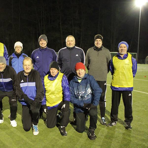 Eine Fußballmannschaft bestehend aus 11 Männern und einer Frau posiert für ein Gruppenfoto