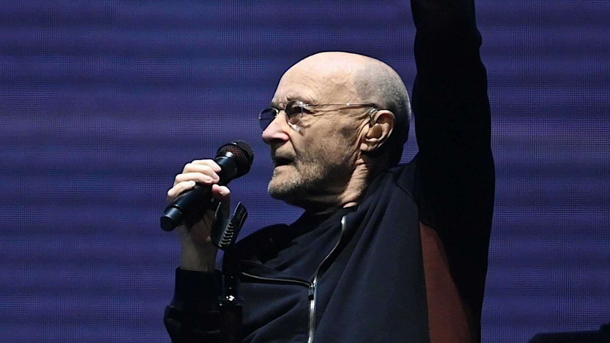 Phil Collins sitzt in der Mercedes-Benz Arena auf der Bühne.