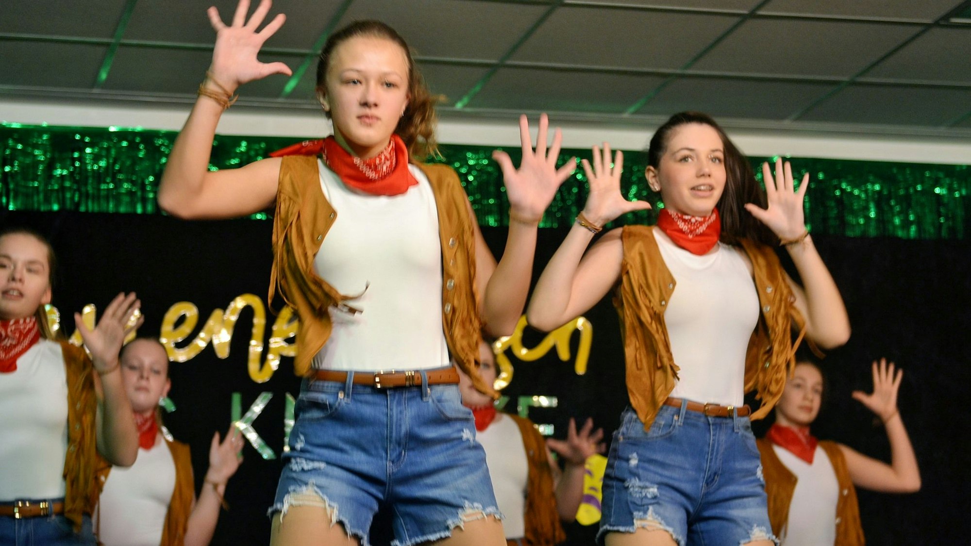 Tanzende Cowgirls zeigen auf der Karnevalsbühne ihre Choreografie.