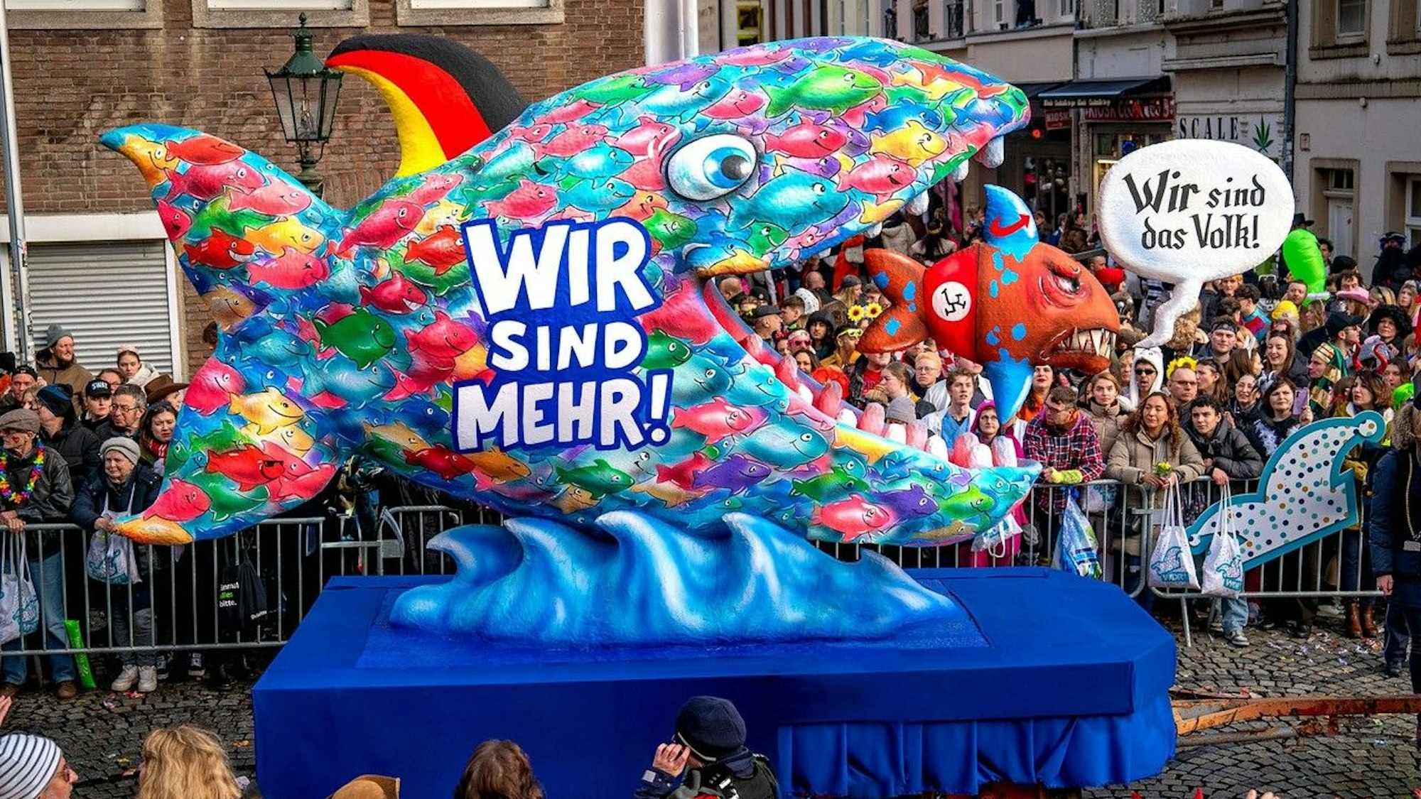 Ein bunter Fisch frisst einen kleinen mit Nazisymbol. Der kleien sagt: Wir sind das folgt. Der große: Wir sind mehr!
