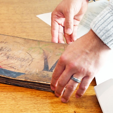 Eine Person begutachtet ein Erinnerungsstück aus der Zeit rund um das Ende des Zweiten Weltkrieges.