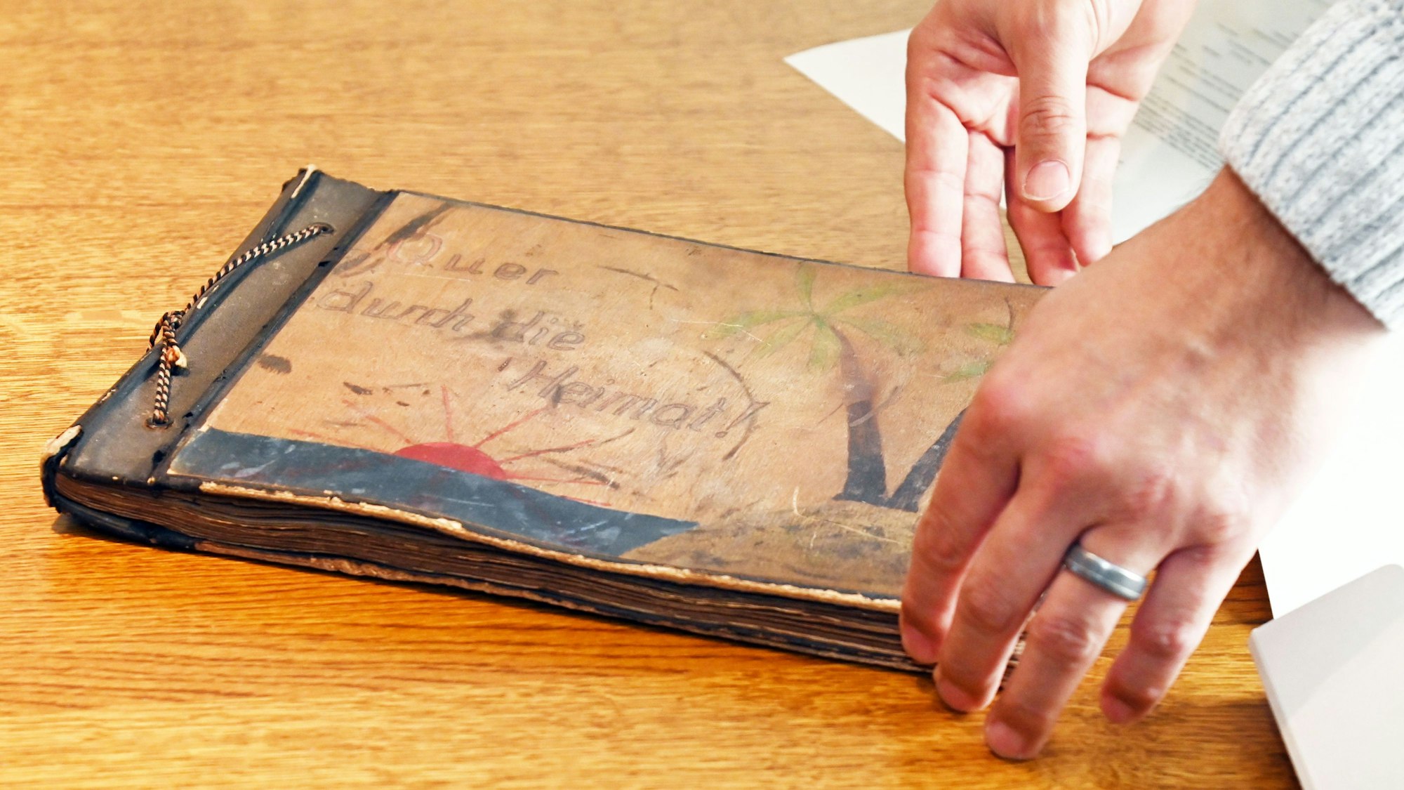 Eine Person begutachtet ein Erinnerungsstück aus der Zeit rund um das Ende des Zweiten Weltkrieges.