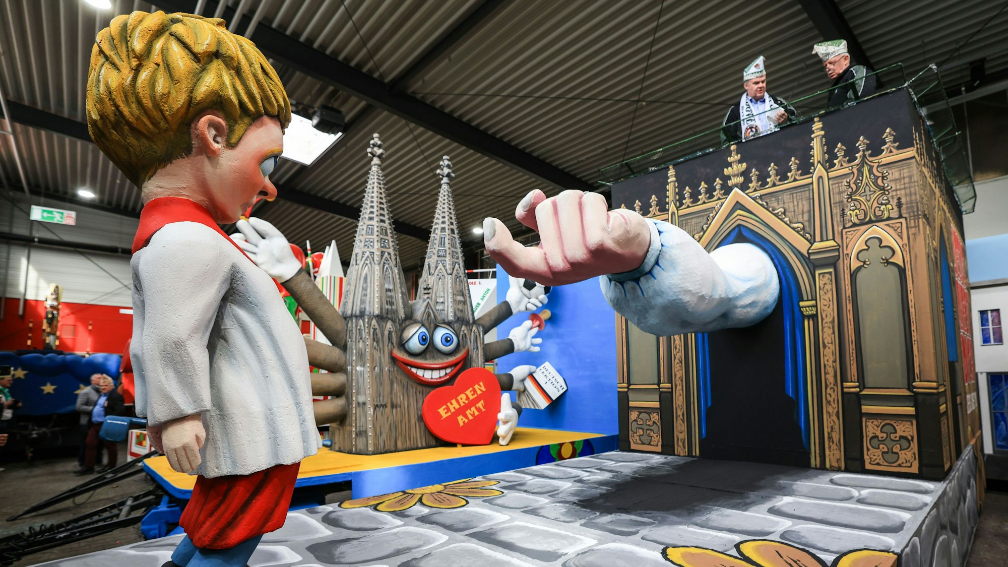 Der Rosenmontagswagen zeigt eine kindliche Figur in Messdienerkleidung. Aus einer Beichtstuhldarstellung ragt ein Arm heraus.