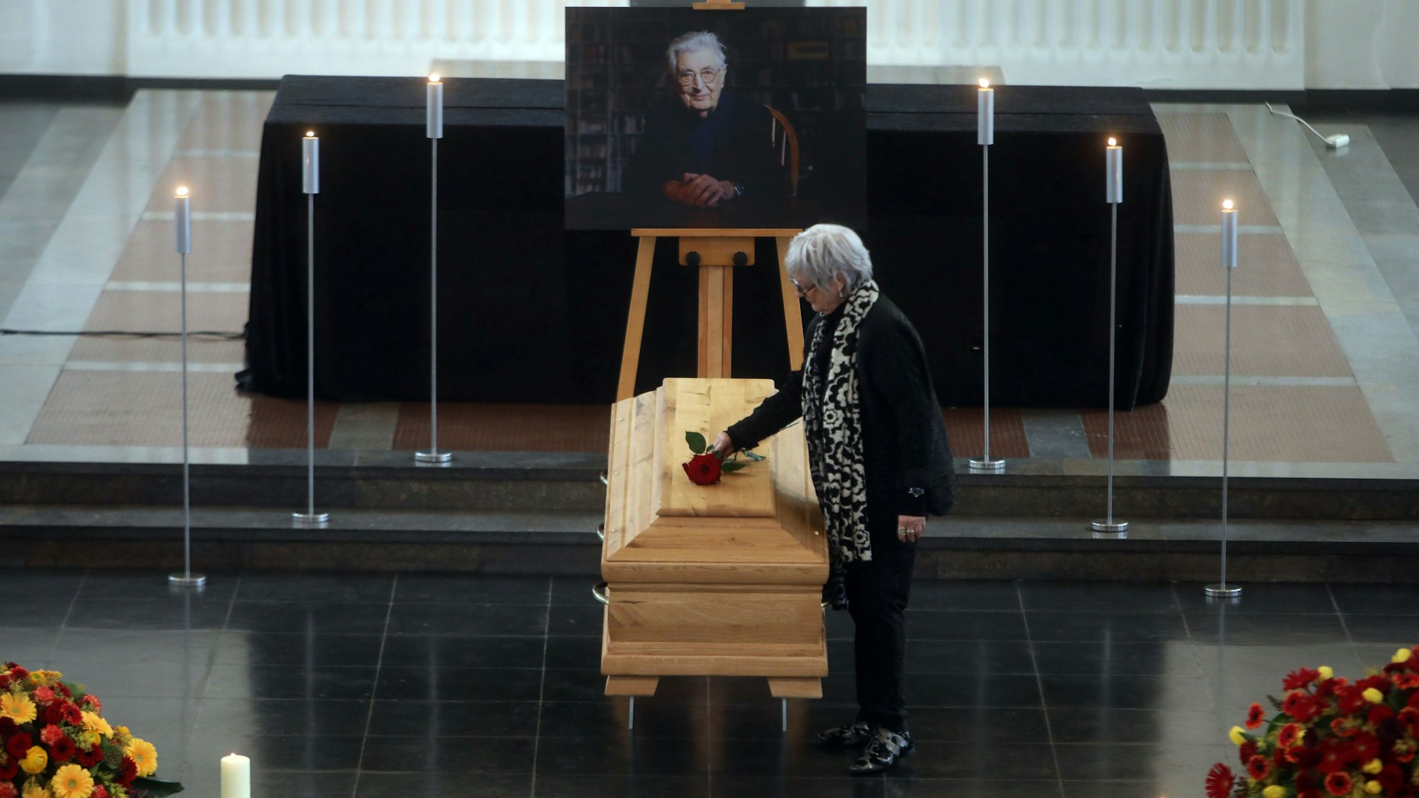 Gerhart Baums Witwe Renate Liesmann-Baum legt eine rote Rose auf den Sarg ihres Mannes.