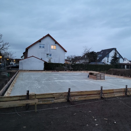 Eine Baustelle, im Hintergrund Wohnhäuser.