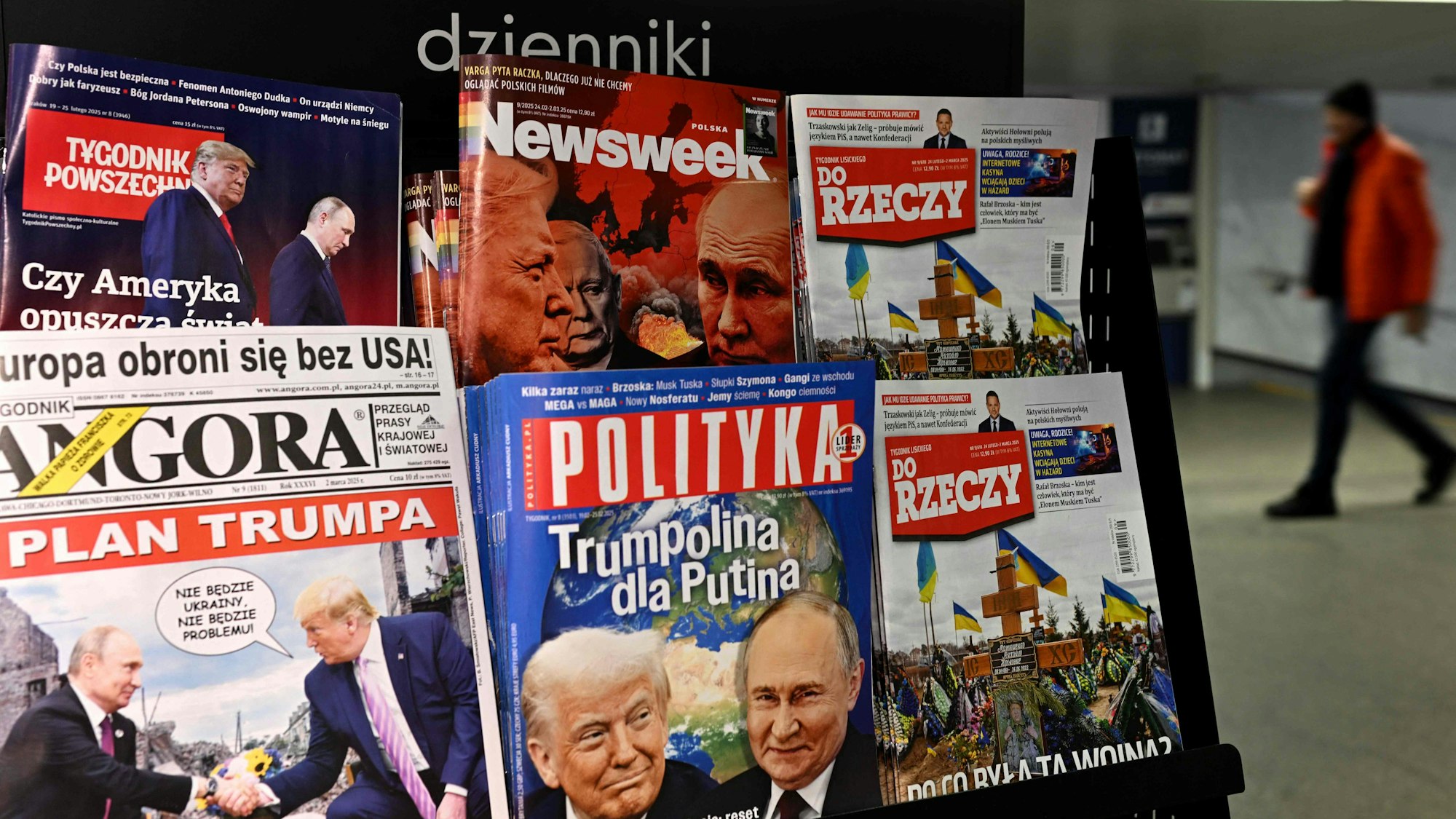 A man walks through an underground passage past a kiosk selling magazines with covers depicting Russia's President Vladimir Putin and US President Donald Trump in Warsaw on February 25, 2025. (Photo by Sergei GAPON / AFP)