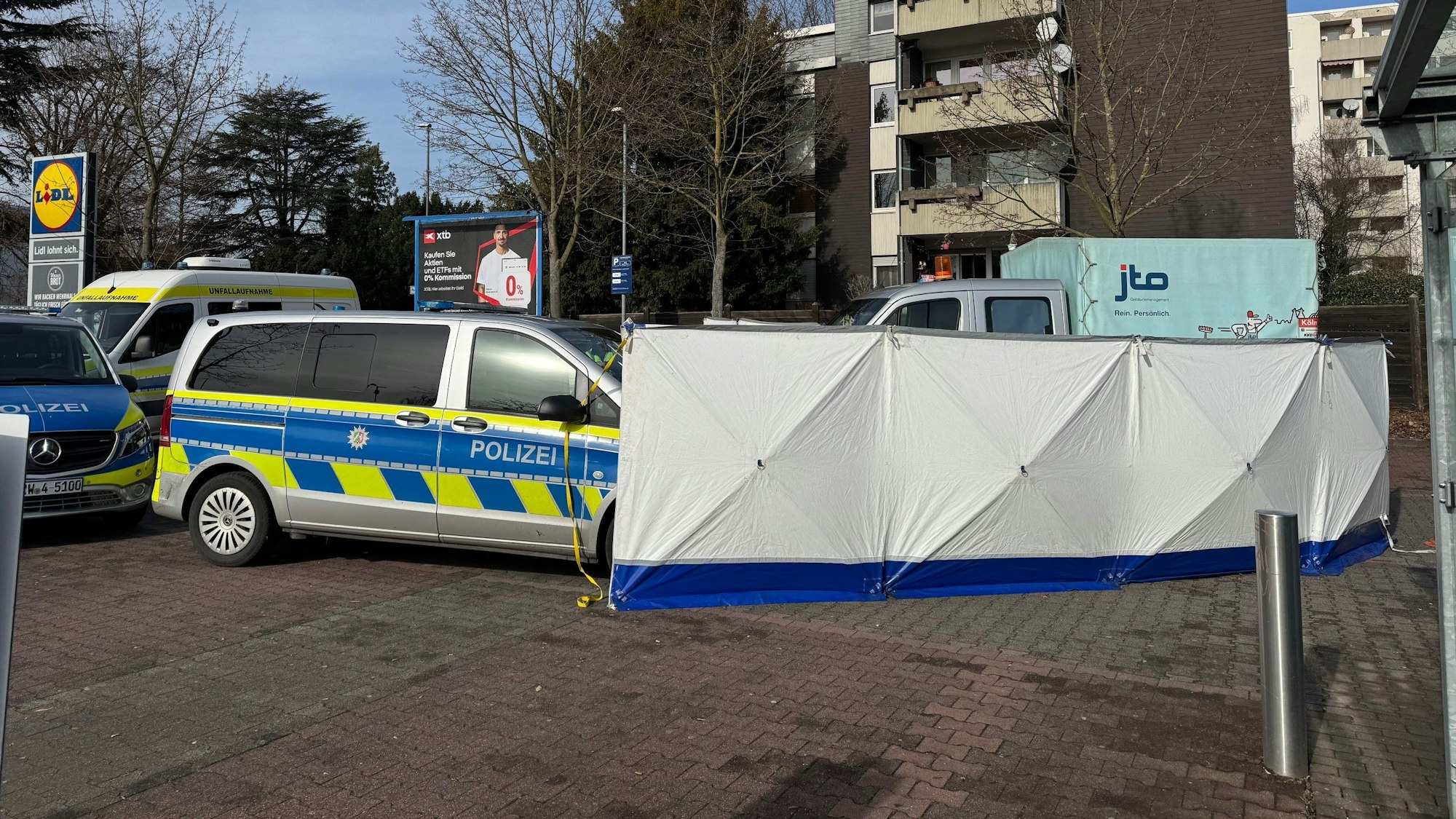Tödlicher Unfall auf dem Lidl-Parkplatz in Köln-Porz. Die Polizei errichtete Sichtschutzwände.