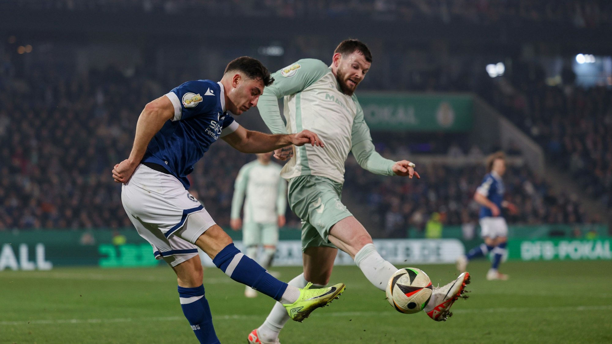 Bielefelds Maximilian Großer (l) im Kampf um den Ball mit Bremens Oliver Burke.