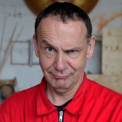 Der Künstler ist im Porträt zu sehen, er zieht eine Augenbraue trotzig-provokant nach oben.