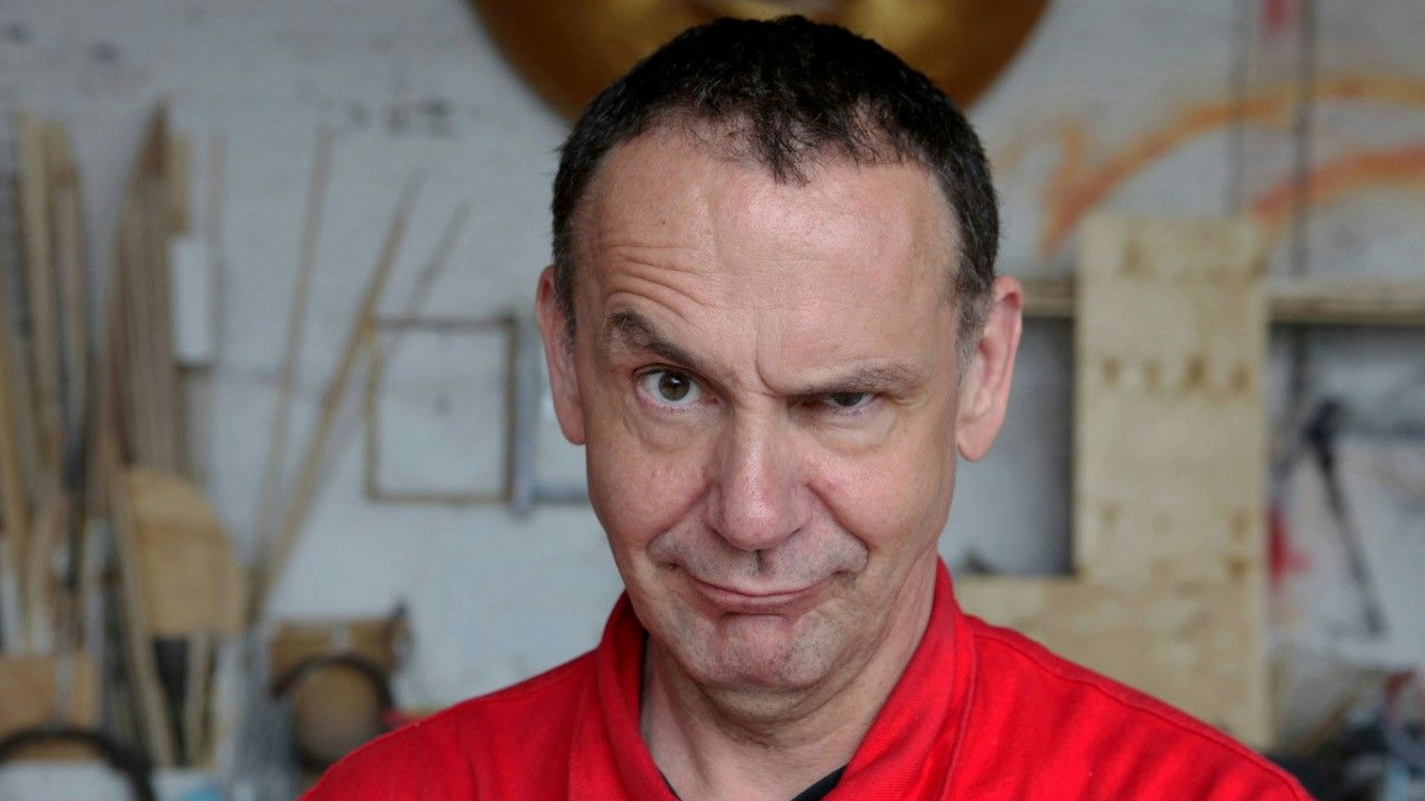 Der Künstler ist im Porträt zu sehen, er zieht eine Augenbraue trotzig-provokant nach oben.