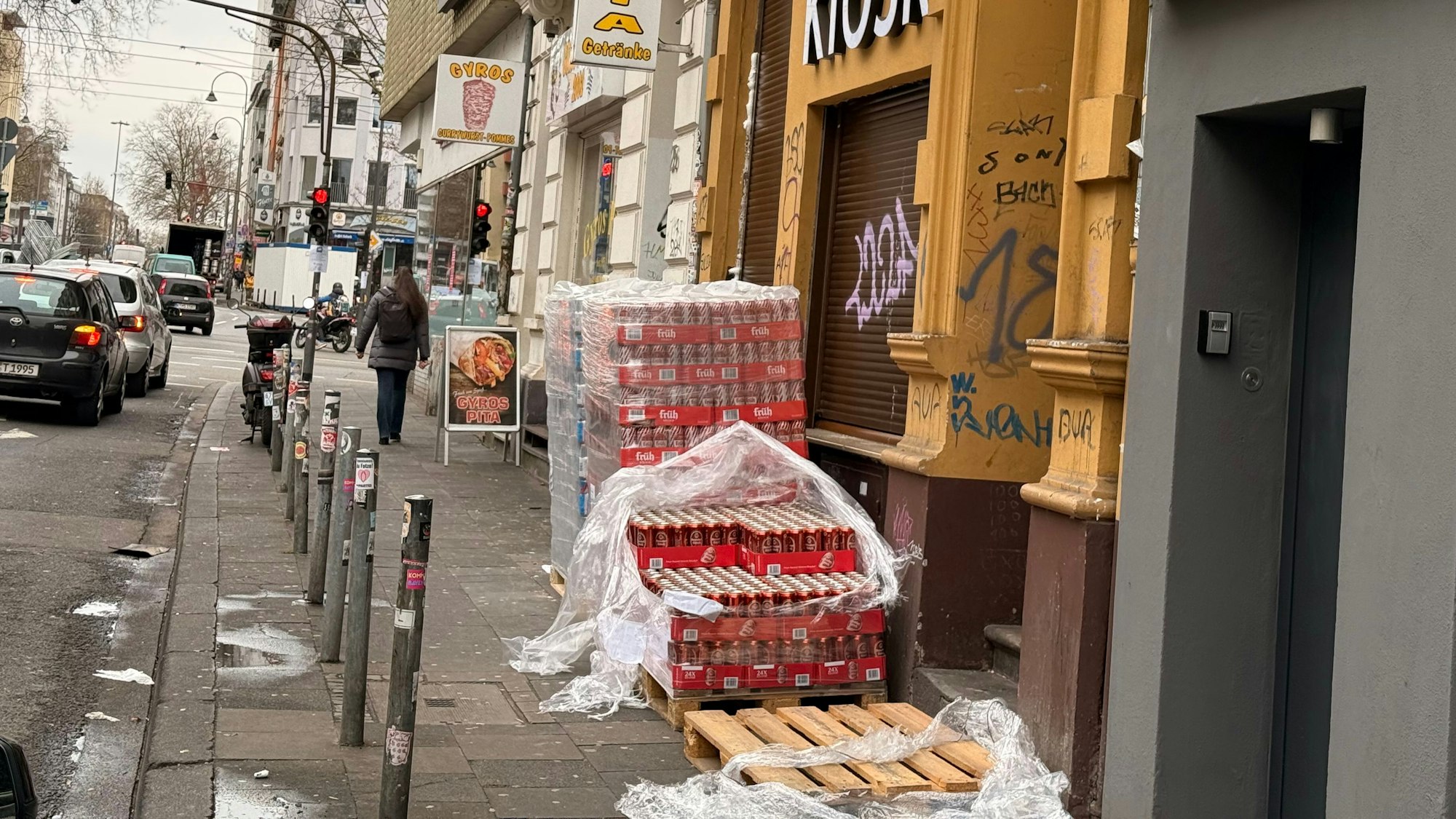 Vor einem Kiosk lagern Dosen auf Europaletten