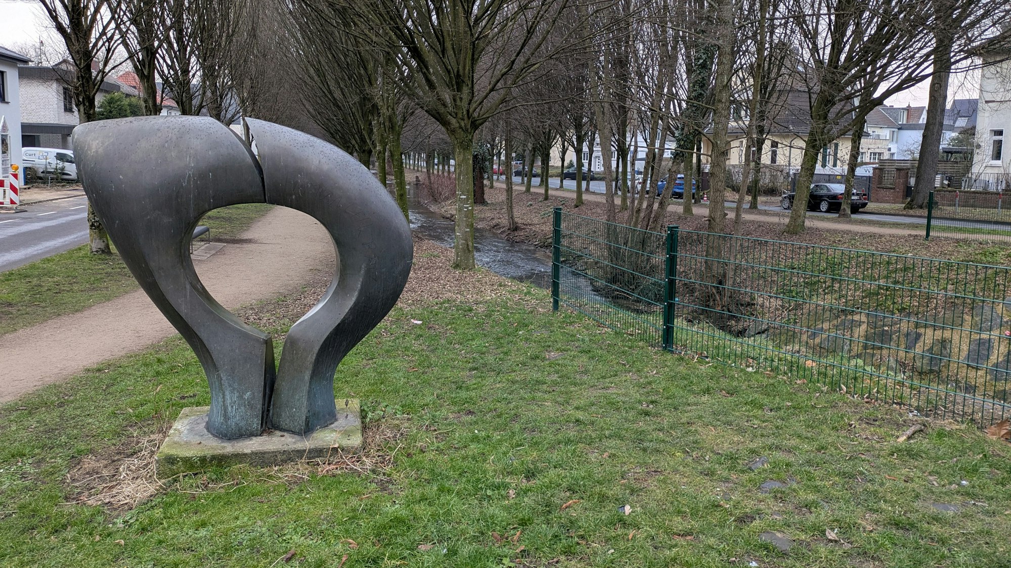 Eine Skulptur steht neben einem Bach.