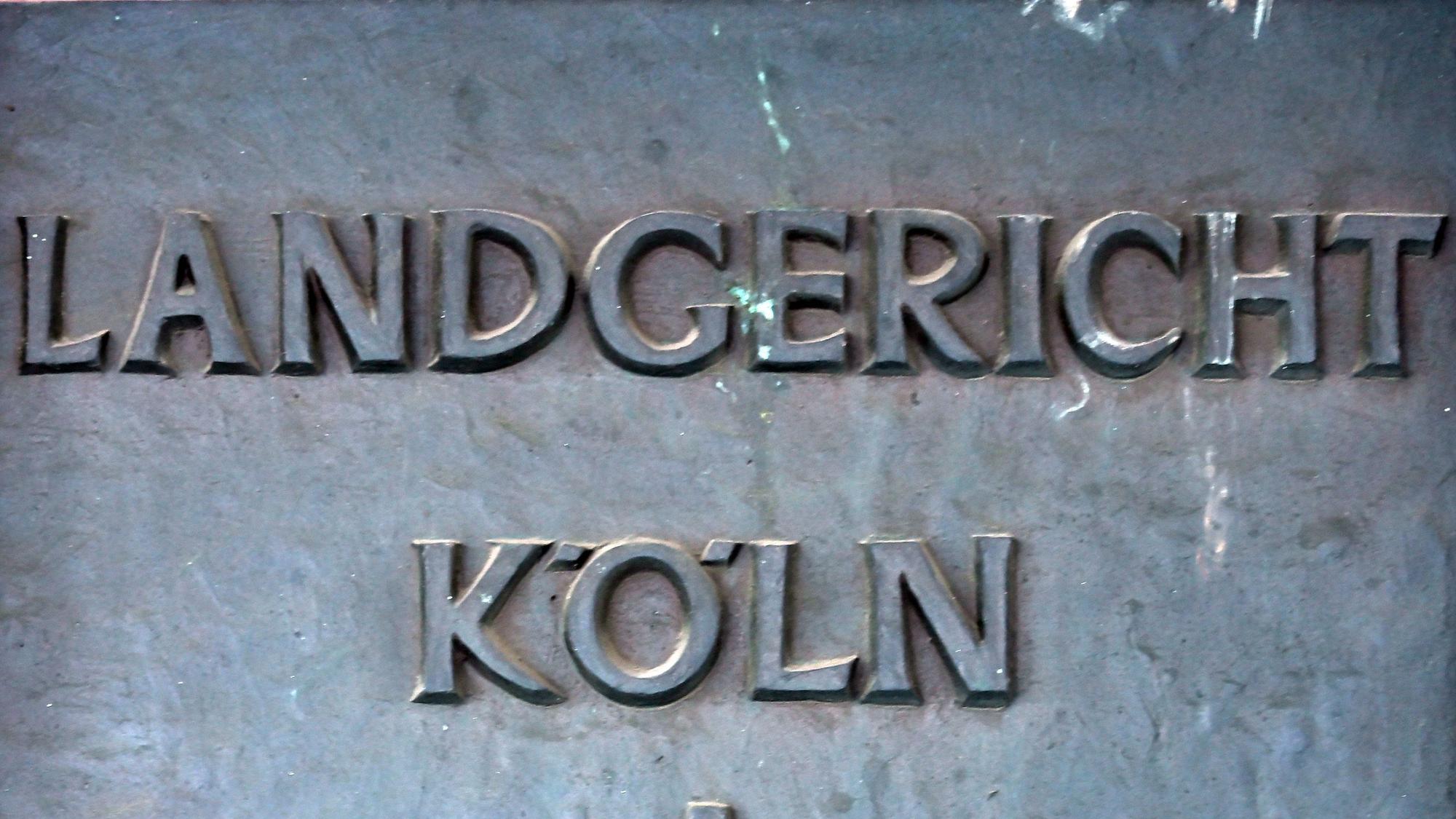 Ein Schild weist auf das Landgericht in Köln hin.