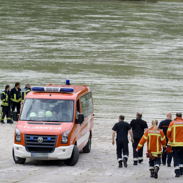 Ein Feuerwehrfahrzeug und Feuerwehrleute stehen am Rheinufer (Symbolfoto).