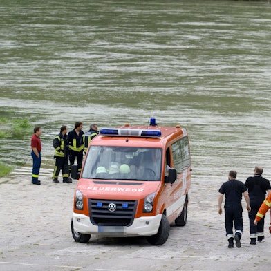 Ein Feuerwehrfahrzeug und Feuerwehrleute am Rhein (Symbolfoto).