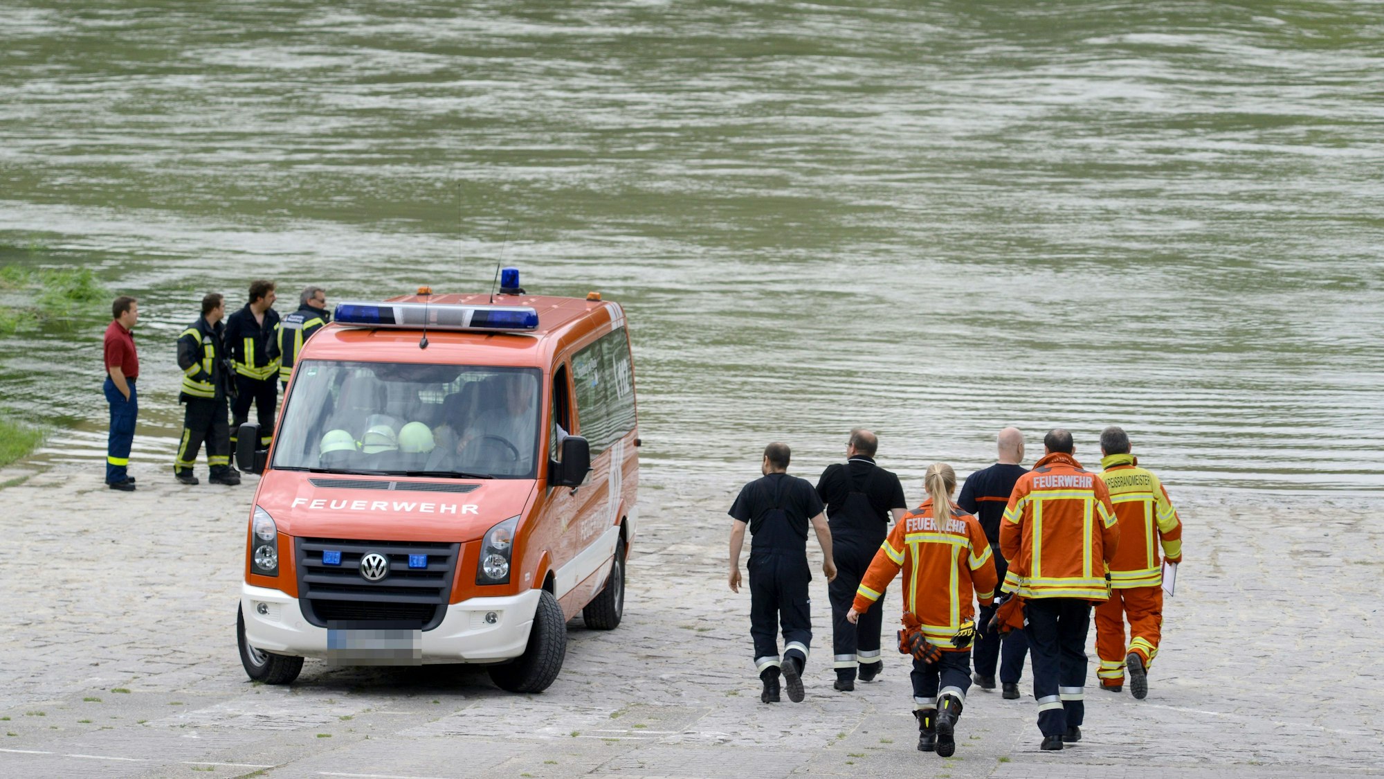 Ein Feuerwehrfahrzeug und Feuerwehrleute am Rhein (Symbolfoto).