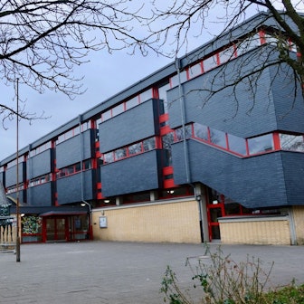 Ein dreigeschossiges Schulgebäude ist zu sehen.