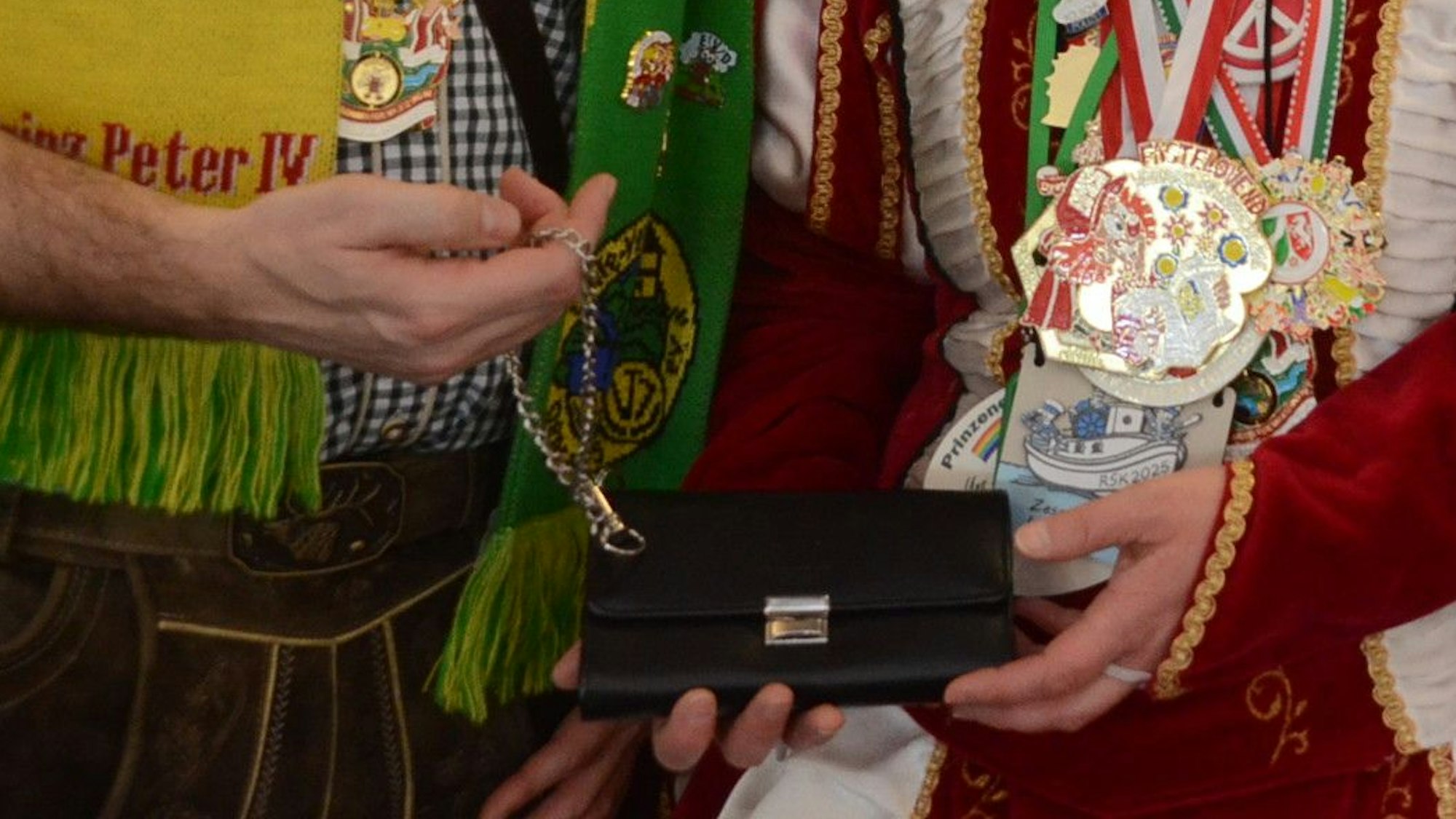 Kostümierte Menschen zeigen ein Portemonnaie, wie es die Bedienungen in der Gastronomie benutzen.