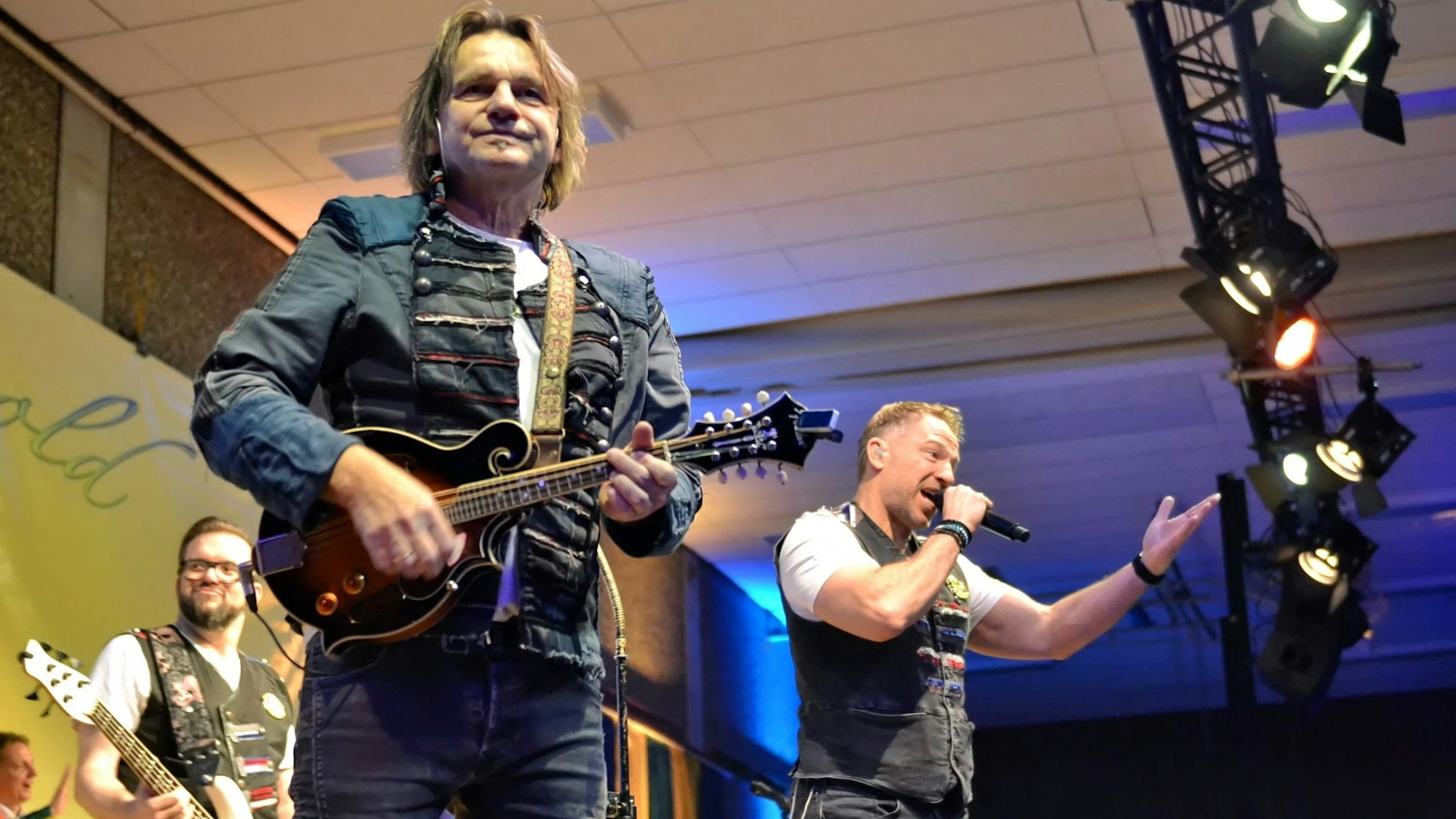 Drei Musiker der Höhner auf der Bühne.