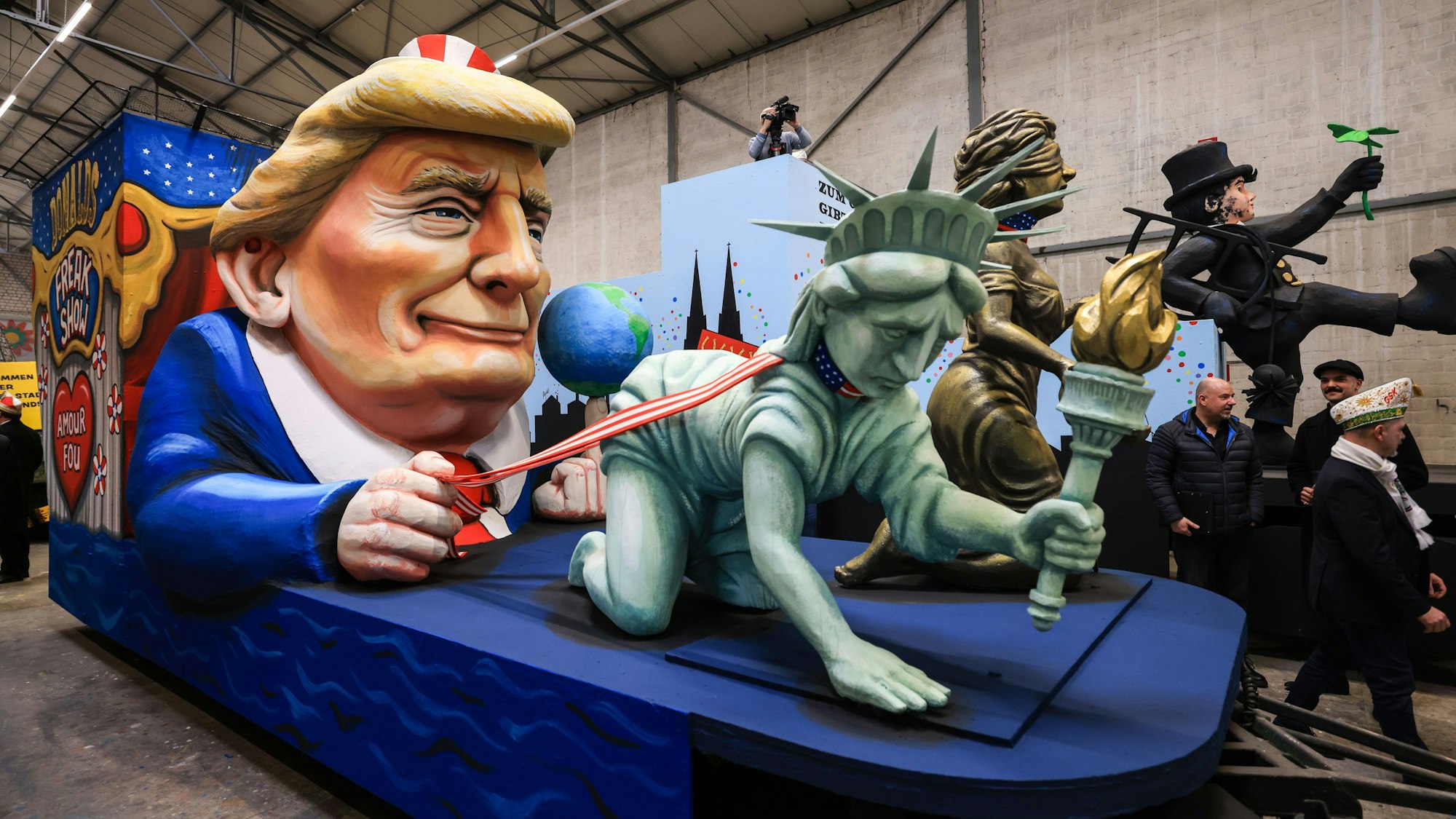 Der Persiflagewagen zeigt eine Trump-Figur mit der Freiheitsstatue an der Leine.