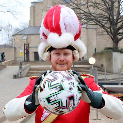 Das Bild zeigt Dirk Lamb, der in rot-weißer Uniform einen Fußball in den Händen hält.